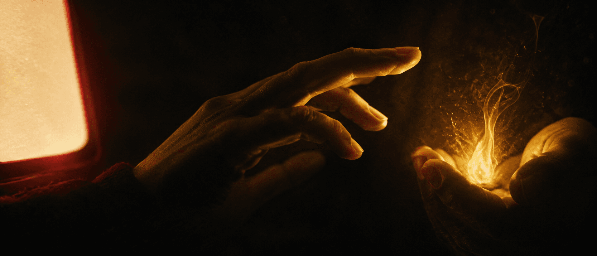An intimate close shot of a single human hand paused mid-reach in the dark, suspended between a cold flat machine glow on one side and a small warm living aurum flame cupped in shadow on the other, the fingers turning toward the inner flame, choosing it first.